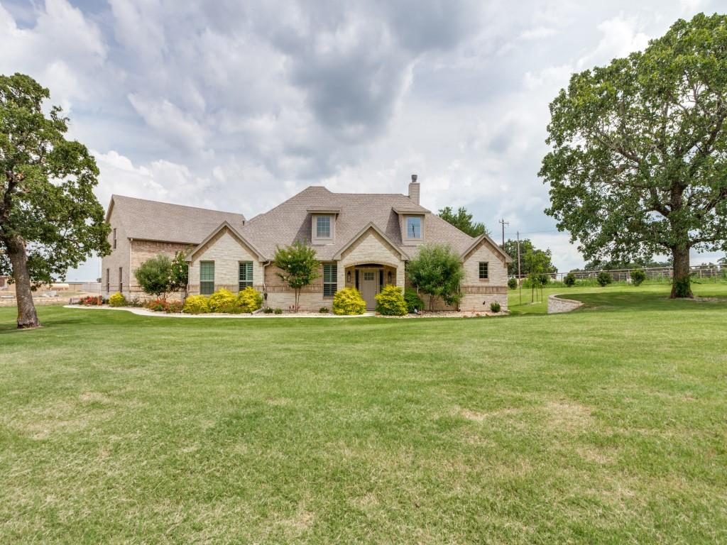 a front view of house with yard and trees