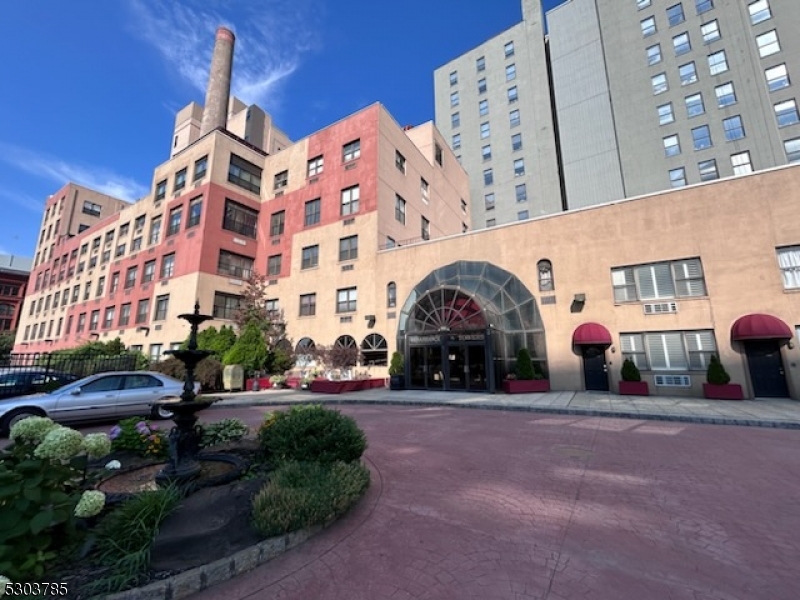 a front view of a building with cars parked