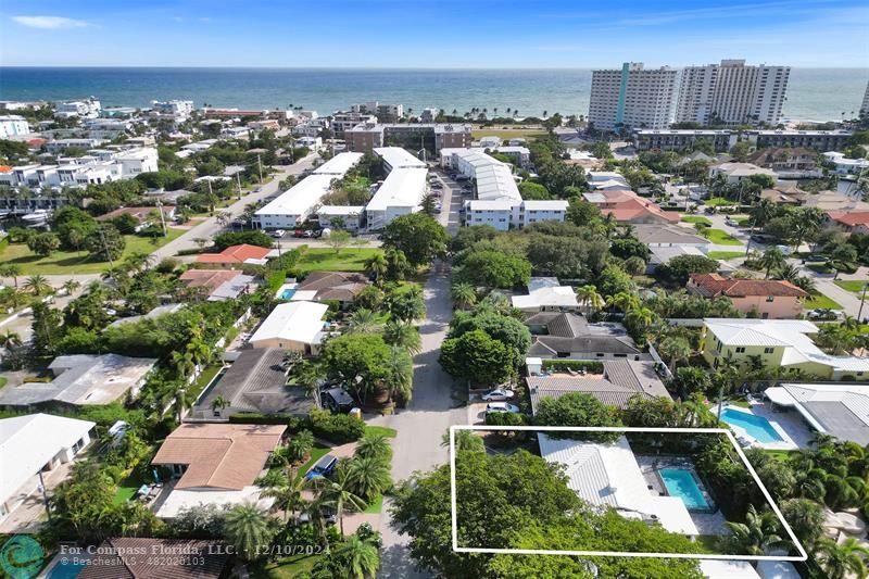 an aerial view of residential houses with outdoor space and ocean view