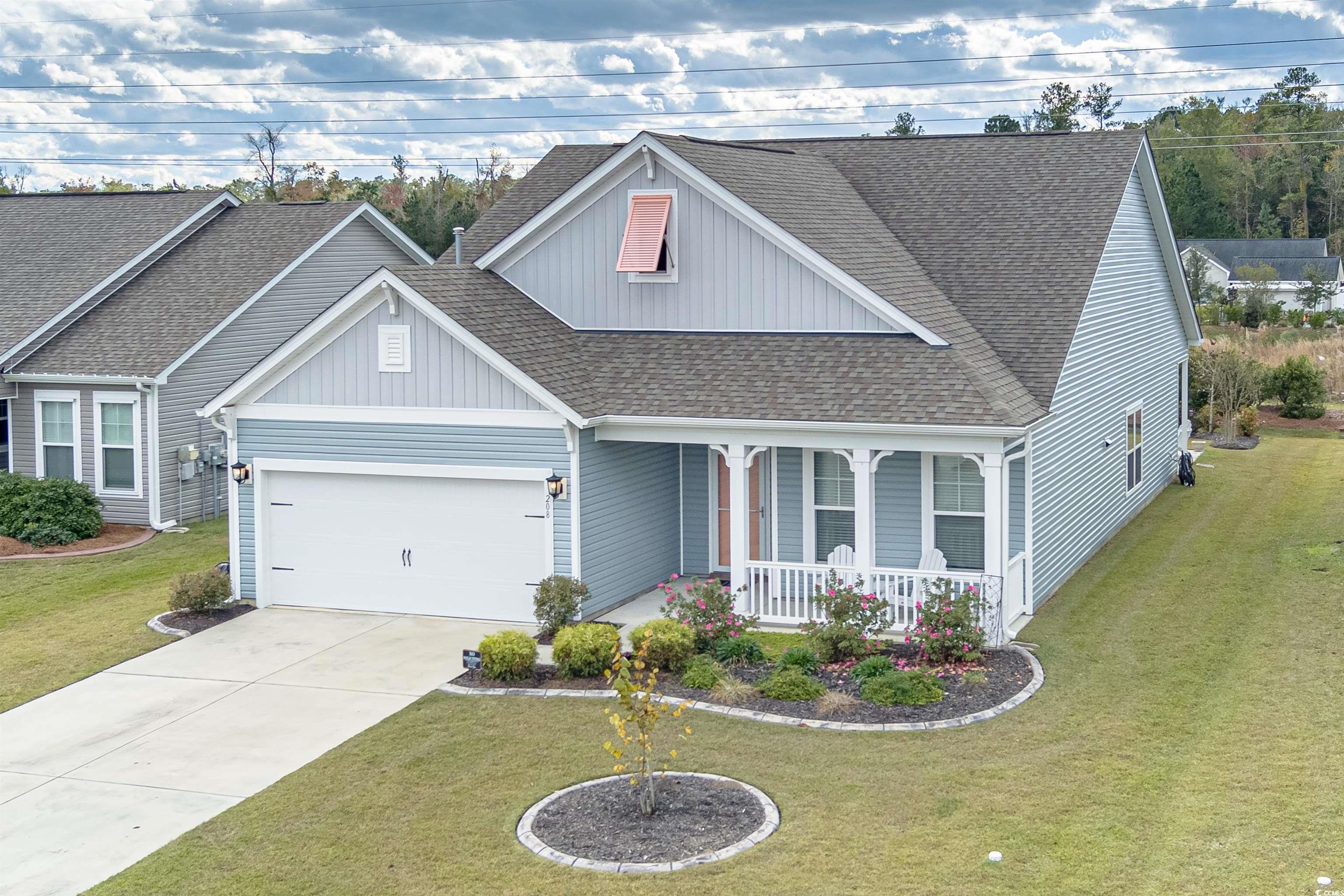 View of front of house with a porch, a garage, and