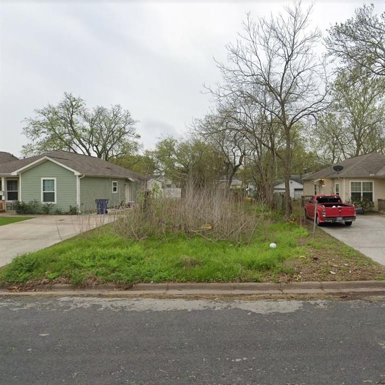 a front view of a house with a garden and trees