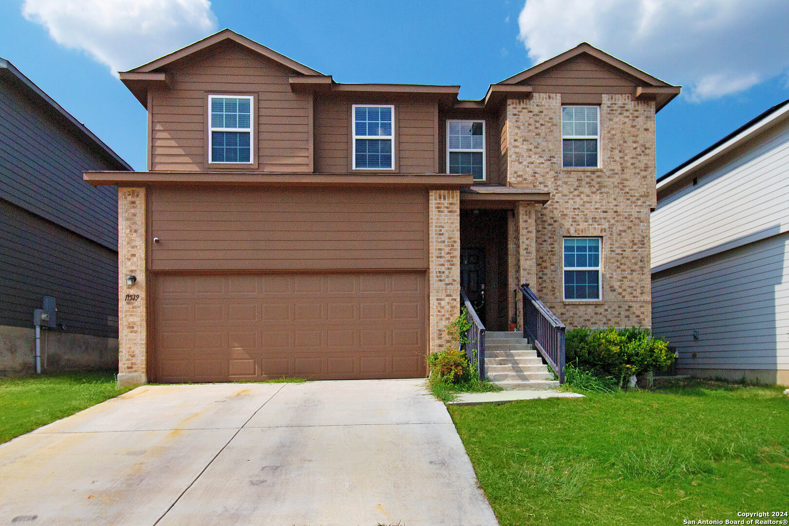 a front view of a house with a yard and garage