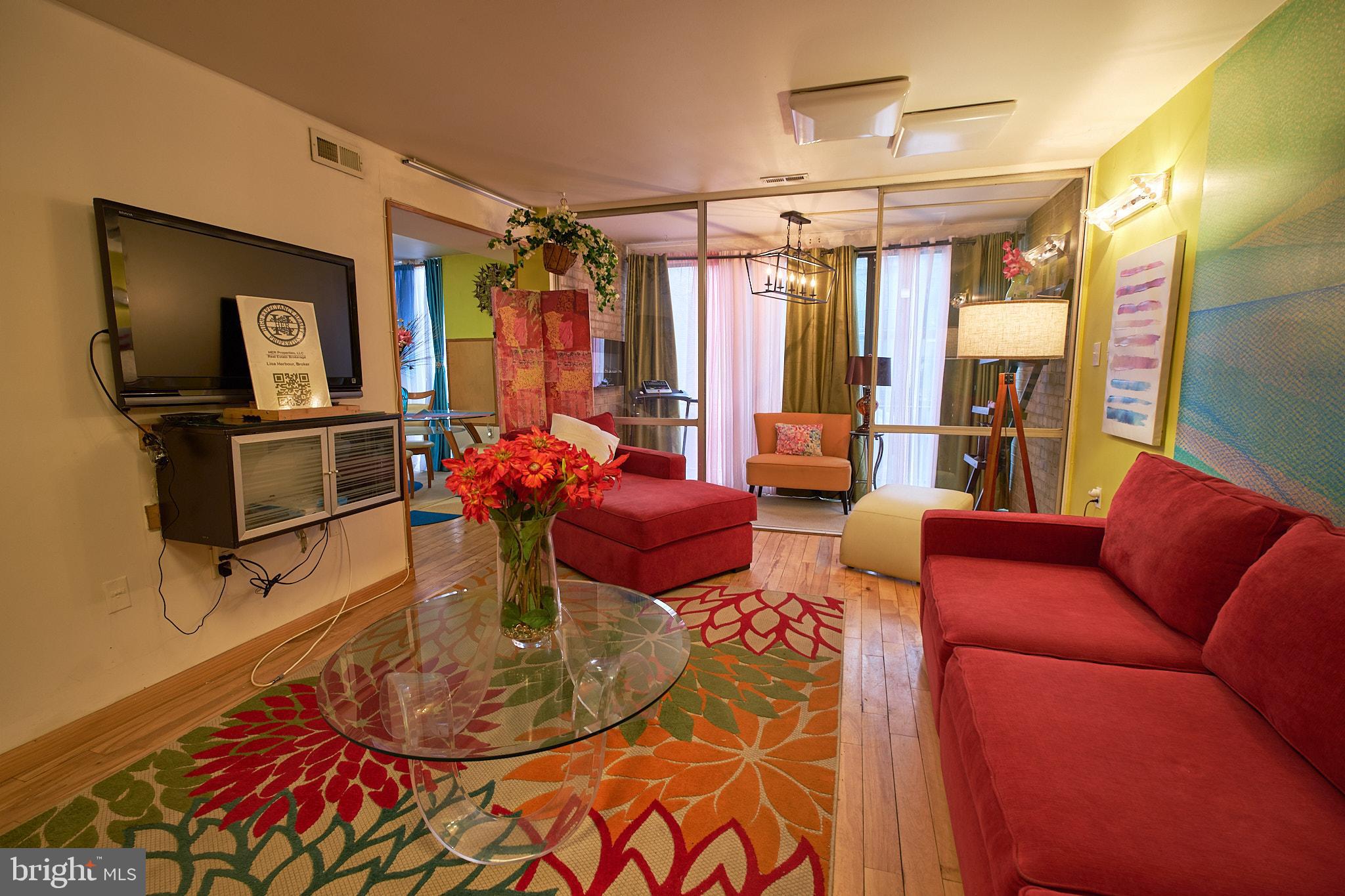 a living room with furniture a chandelier and a dining table