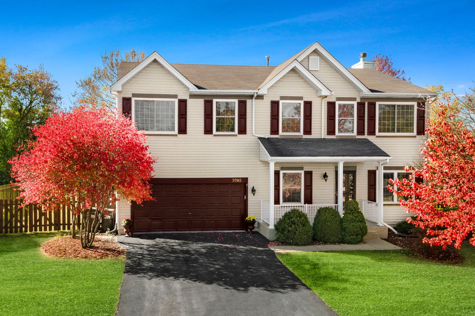 a front view of a house with a yard and trees