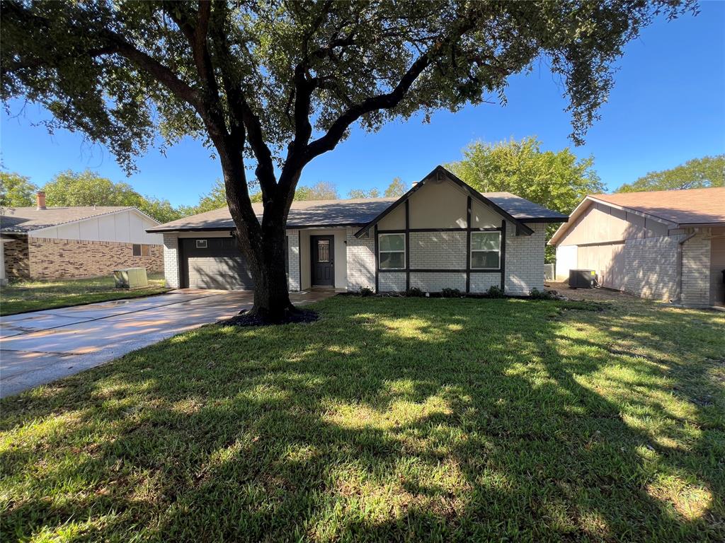 a view of a house with a tree in a yard