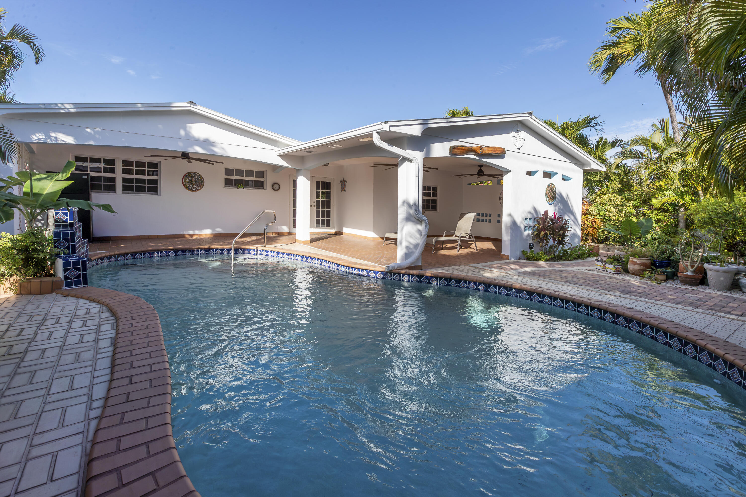 a view of a house with pool and chairs