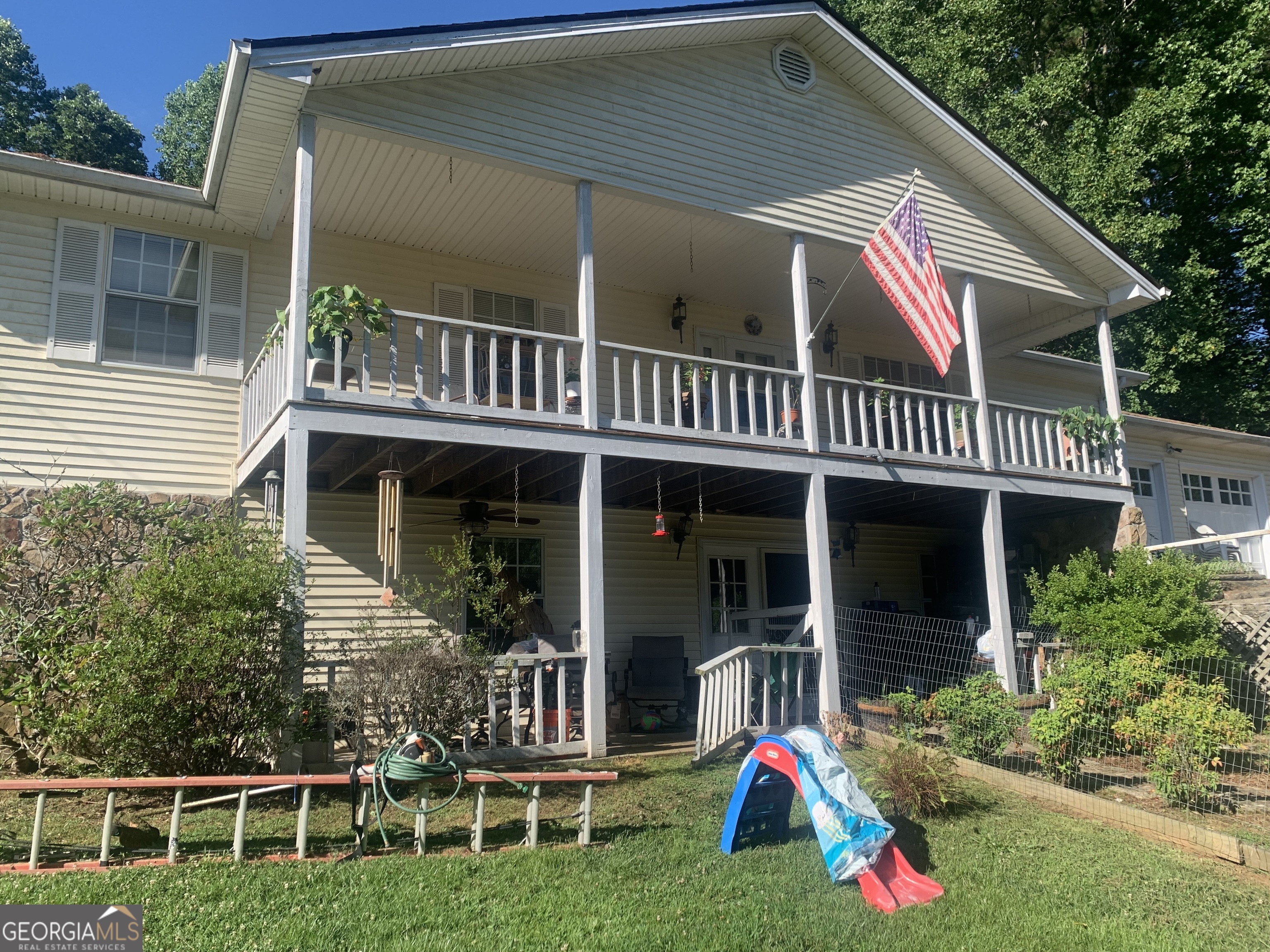 a view of a house with a deck and furniture