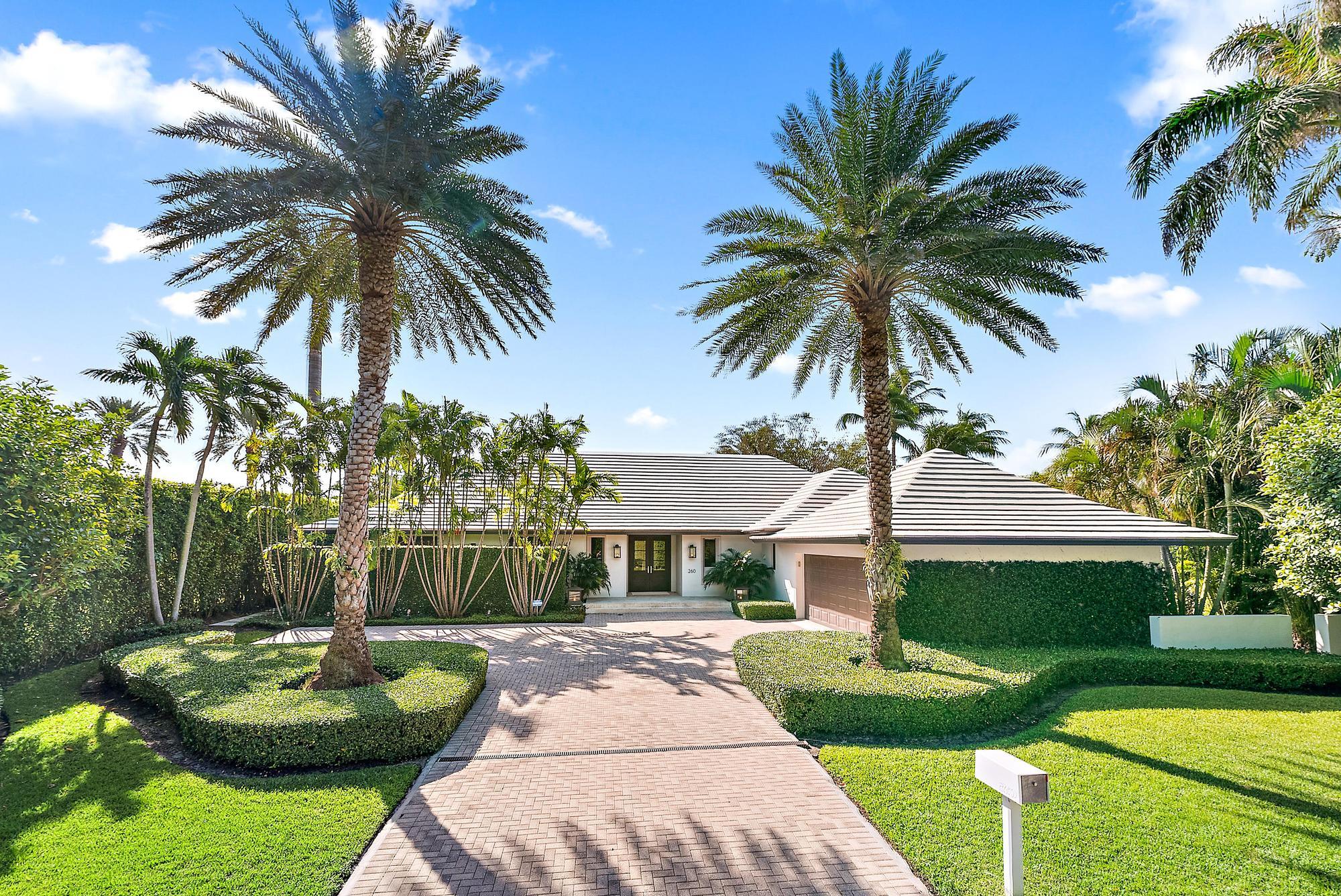 a front view of a house with garden and swimming pool