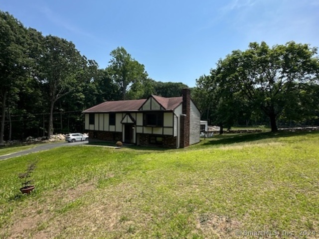 a front view of a house with yard and tree