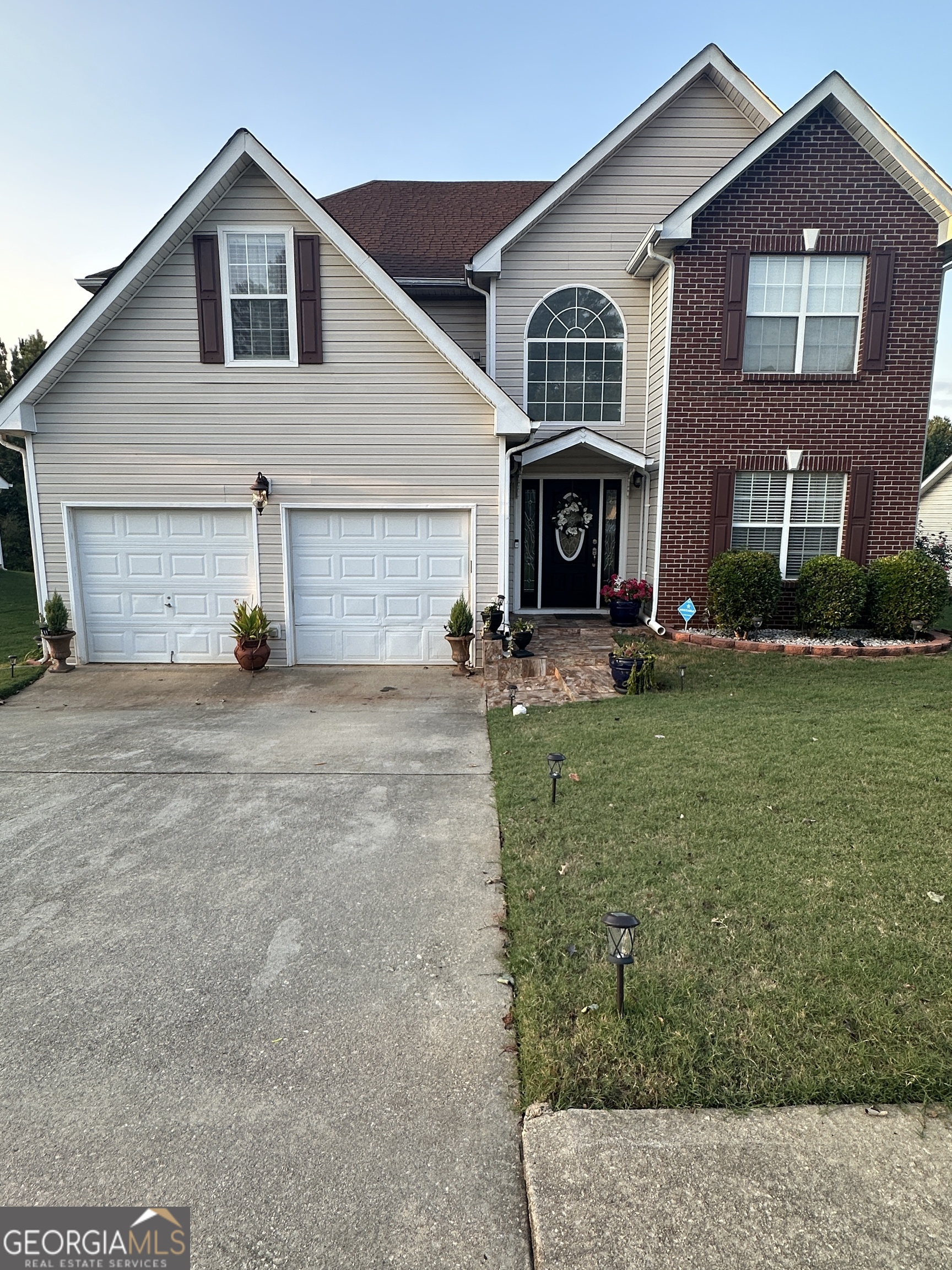 a front view of a house with a yard and garage