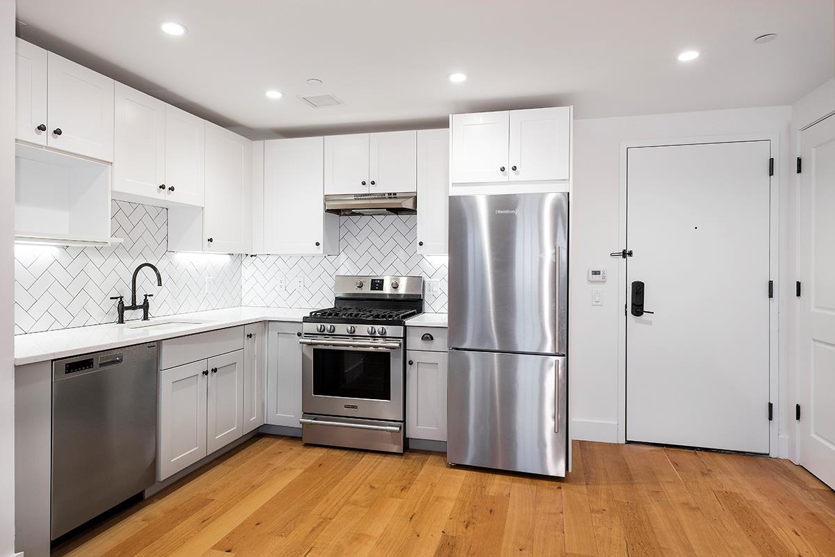 a kitchen with stainless steel appliances granite countertop a refrigerator sink and cabinets