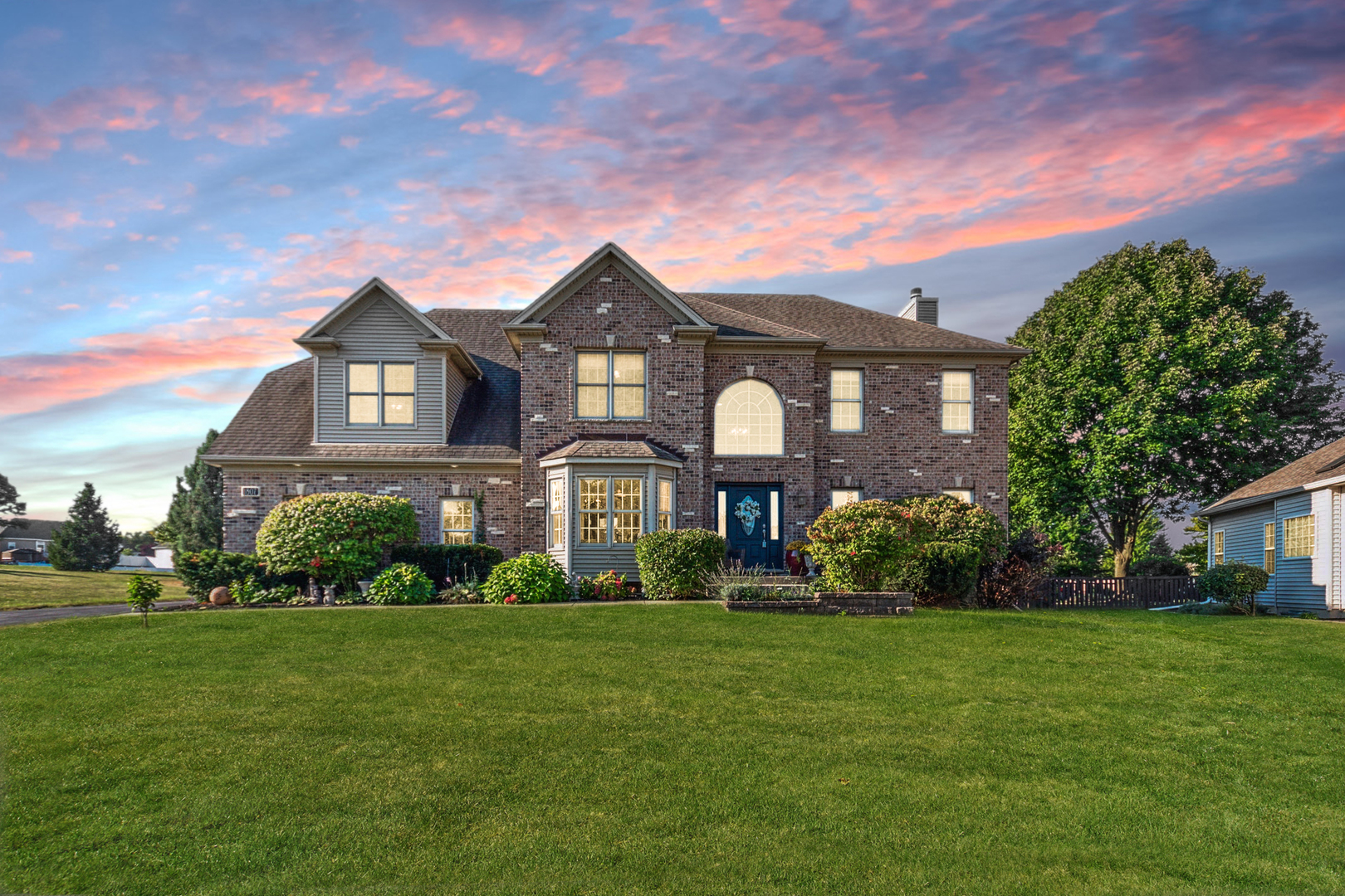 a front view of house with yard and green space