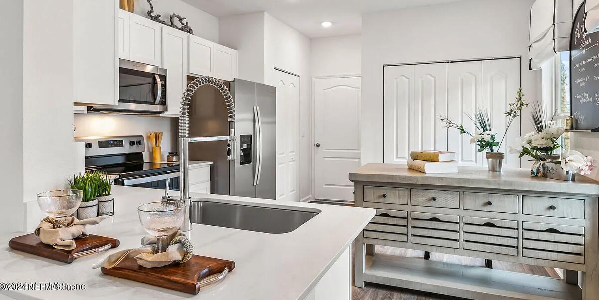 a kitchen with kitchen island a sink stove and refrigerator