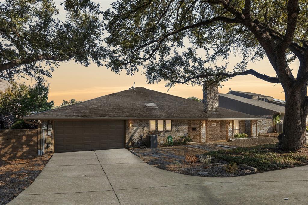 a front view of a house with yard and tree