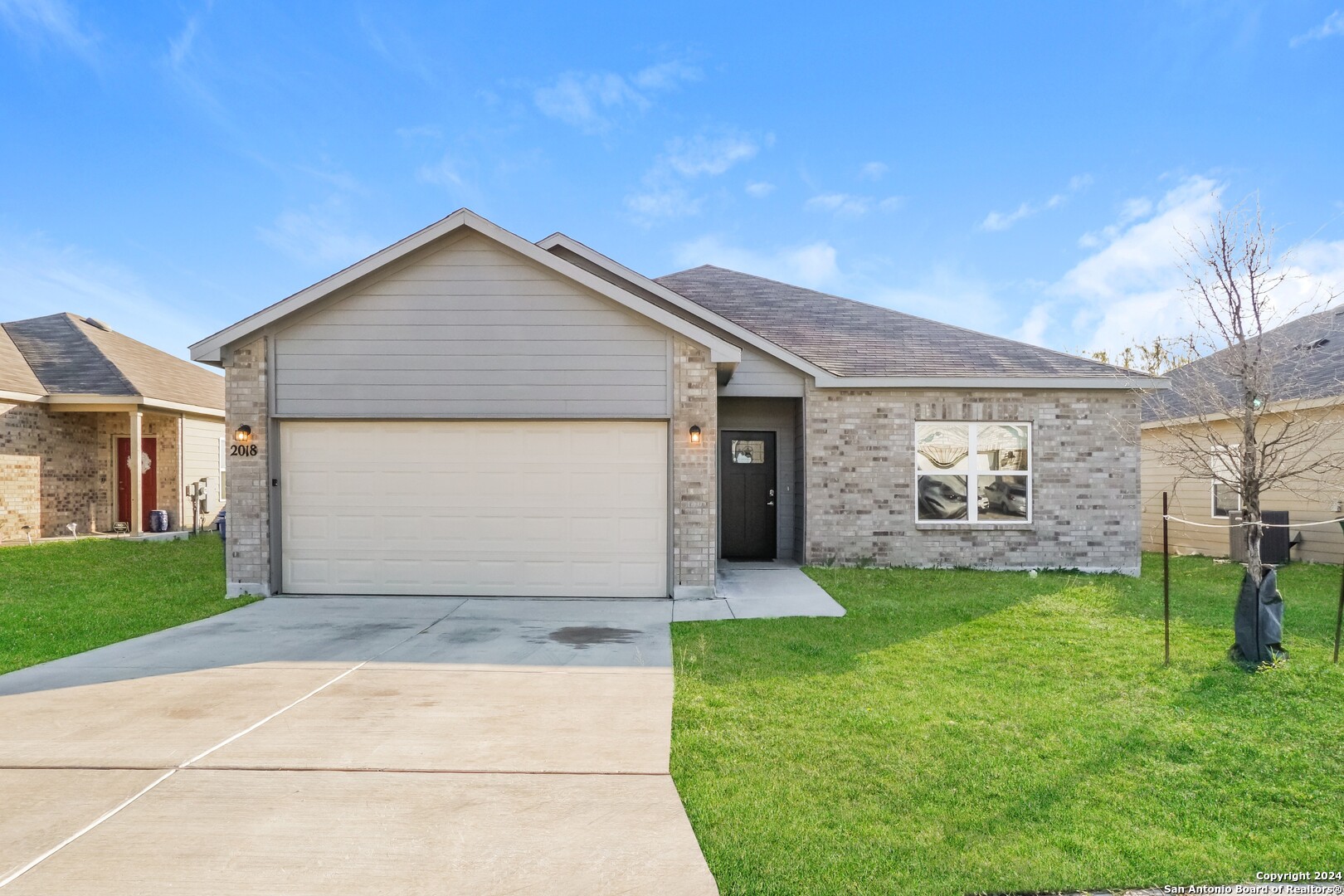 a front view of a house with a yard and garage