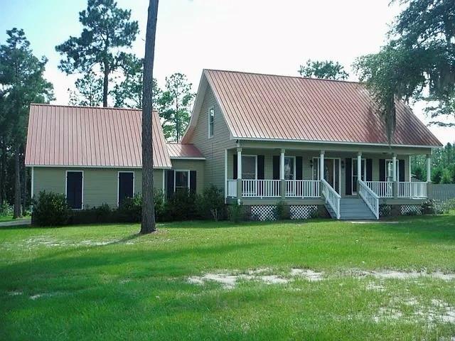 a front view of a house with a garden and trees