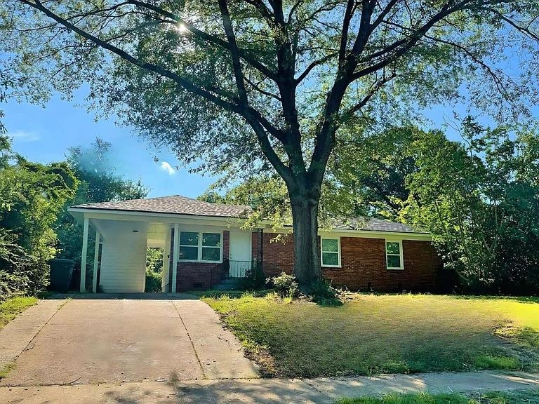 Ranch-style home with a front yard and a carport