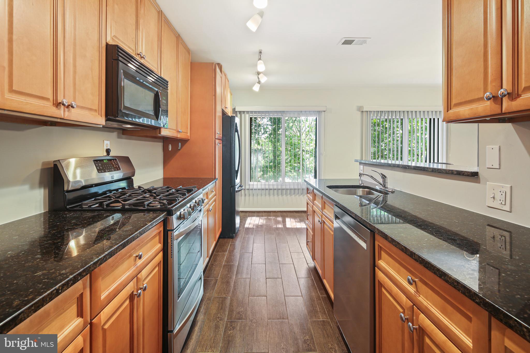 a kitchen with stainless steel appliances granite countertop a stove and a sink