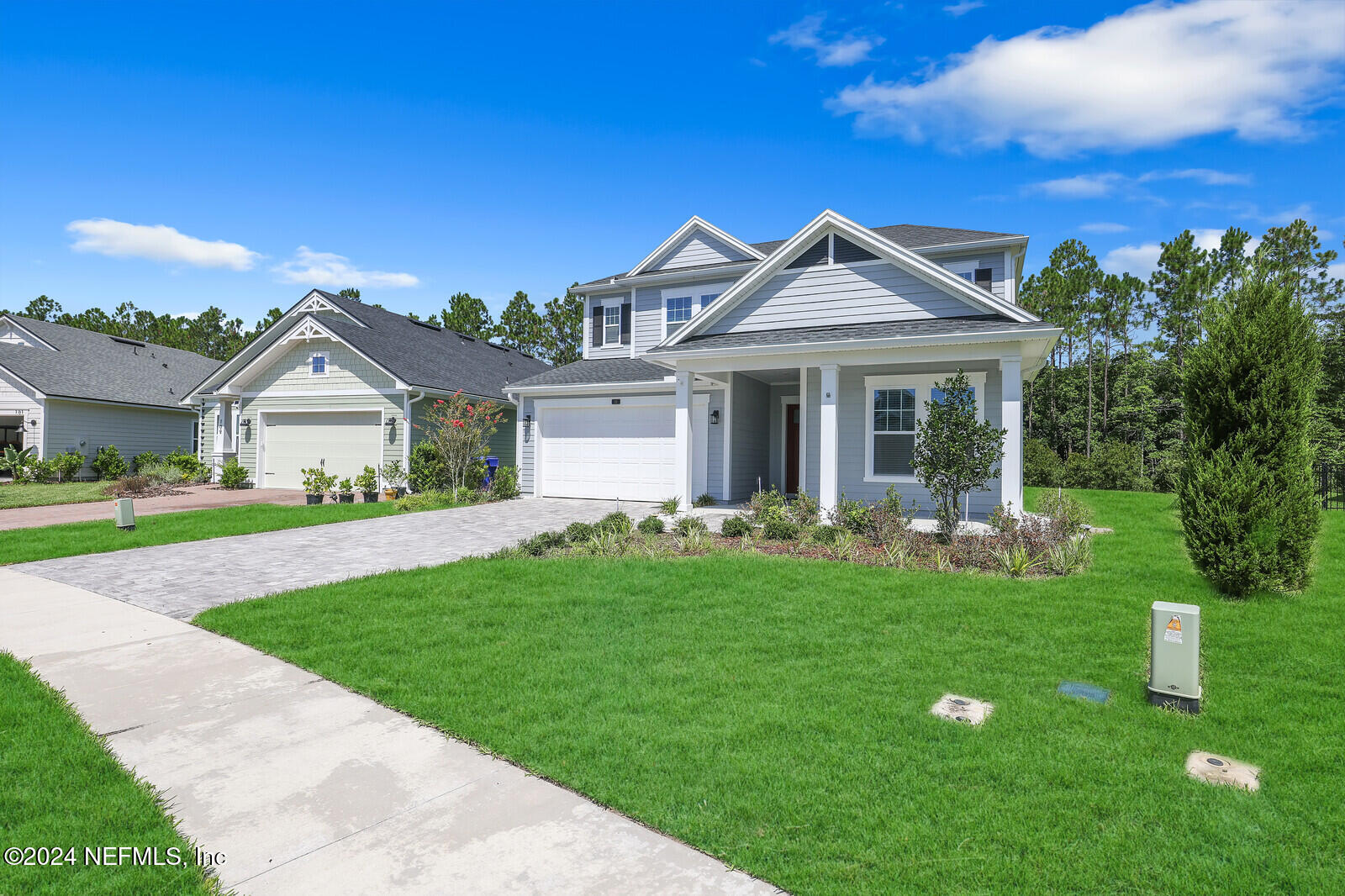 a view of a house with a yard and potted plants