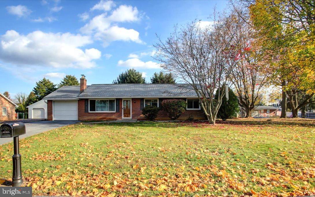 a view of a house with a large tree and a yard