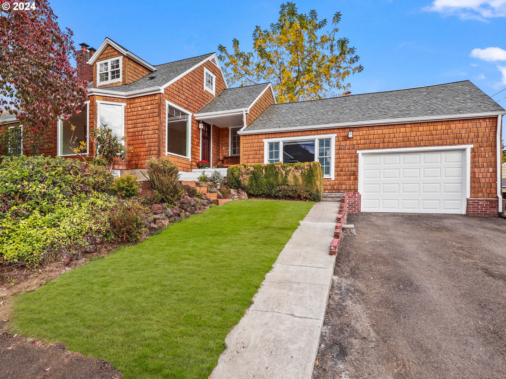 a front view of a house with a garden and yard