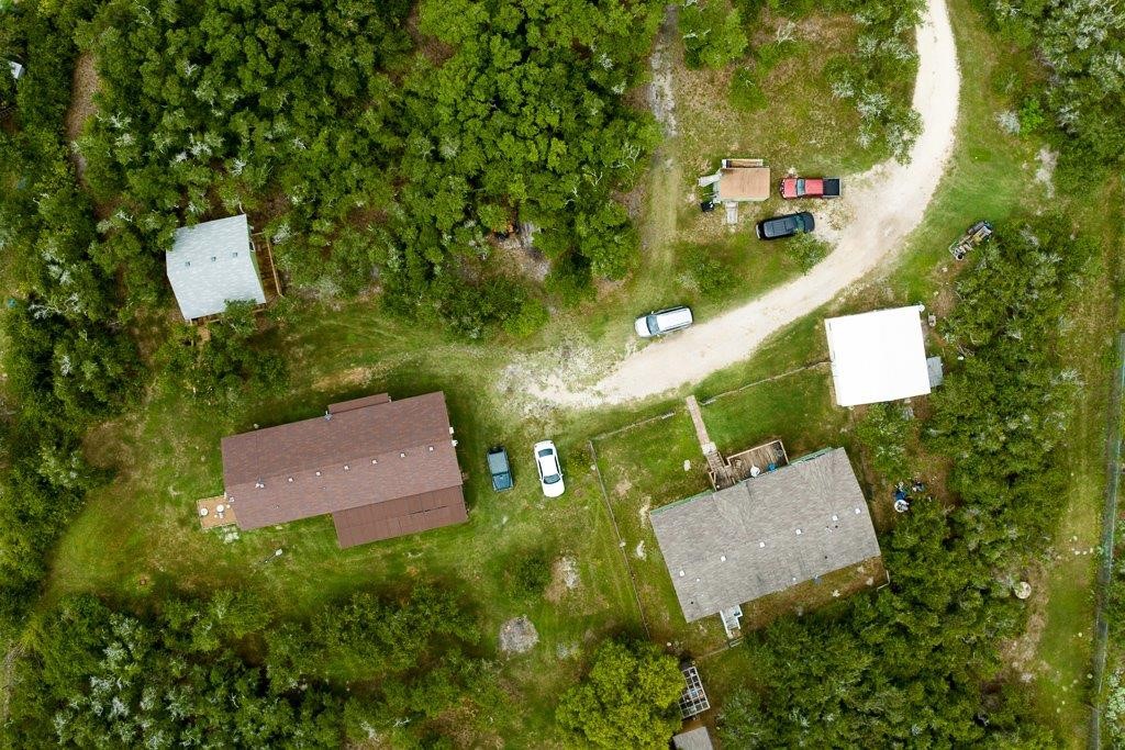 an aerial view of residential house with outdoor space and trees all around