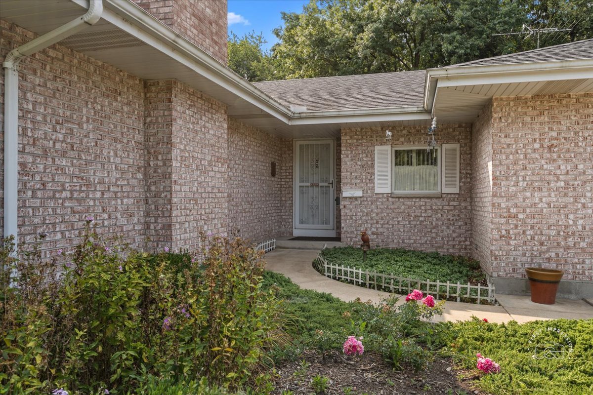 a view of a house with a small yard and potted plants