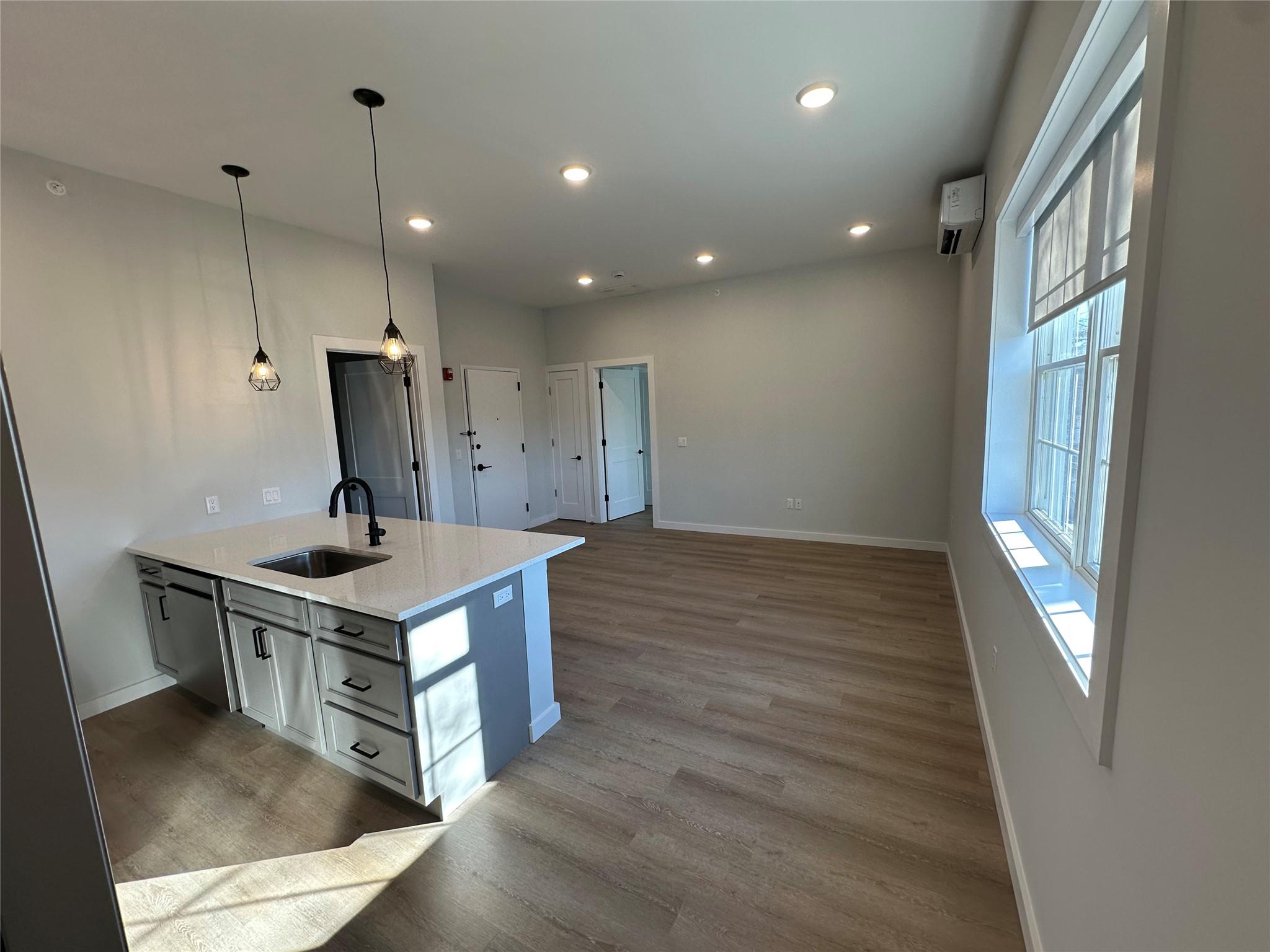 a kitchen that has a sink a stove and a wooden floor