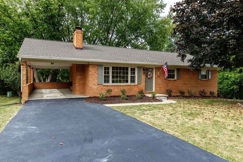 a view of a house with backyard and trees