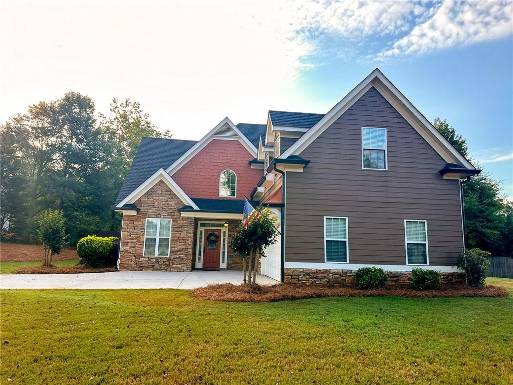 a front view of a house with a garden and yard