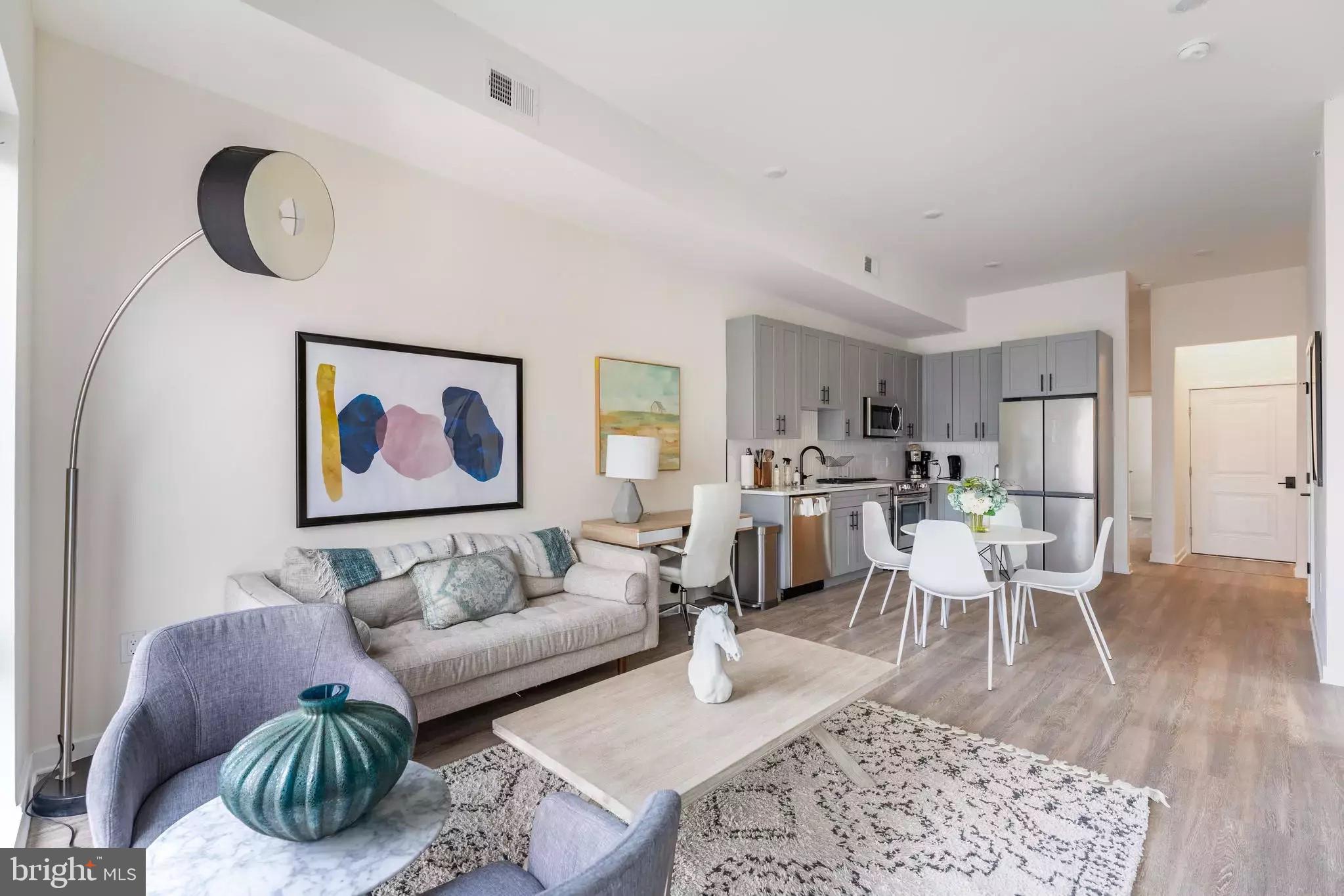 a living room with furniture a rug and kitchen view