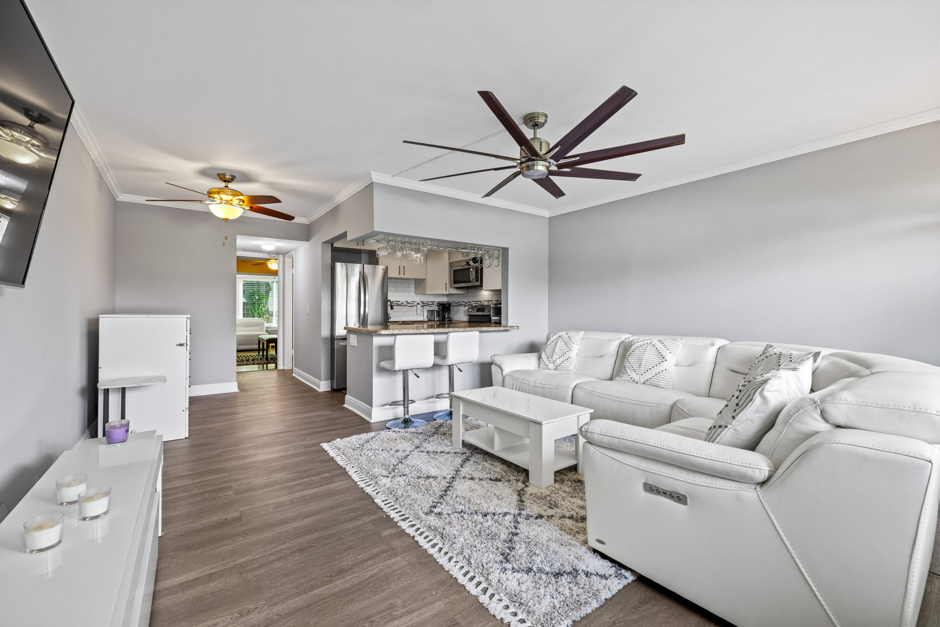 a living room with furniture and view of kitchen