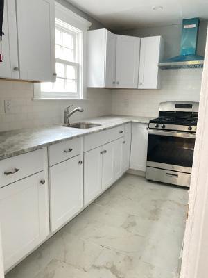 a kitchen with cabinets appliances a sink and a window