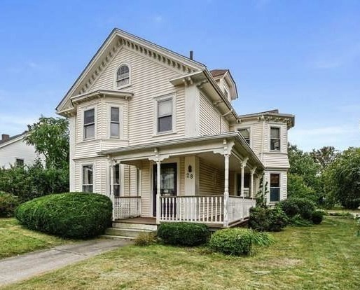 a view of a white house next to a yard