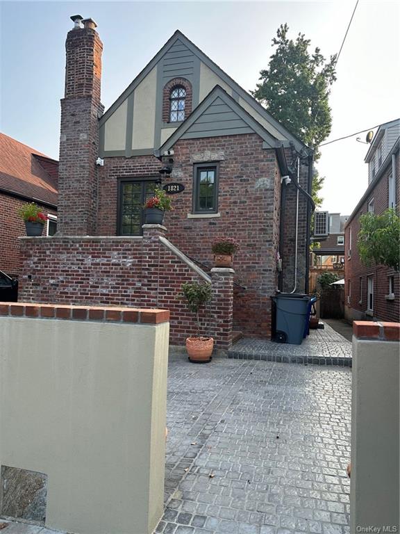 a front view of a house with cars parked