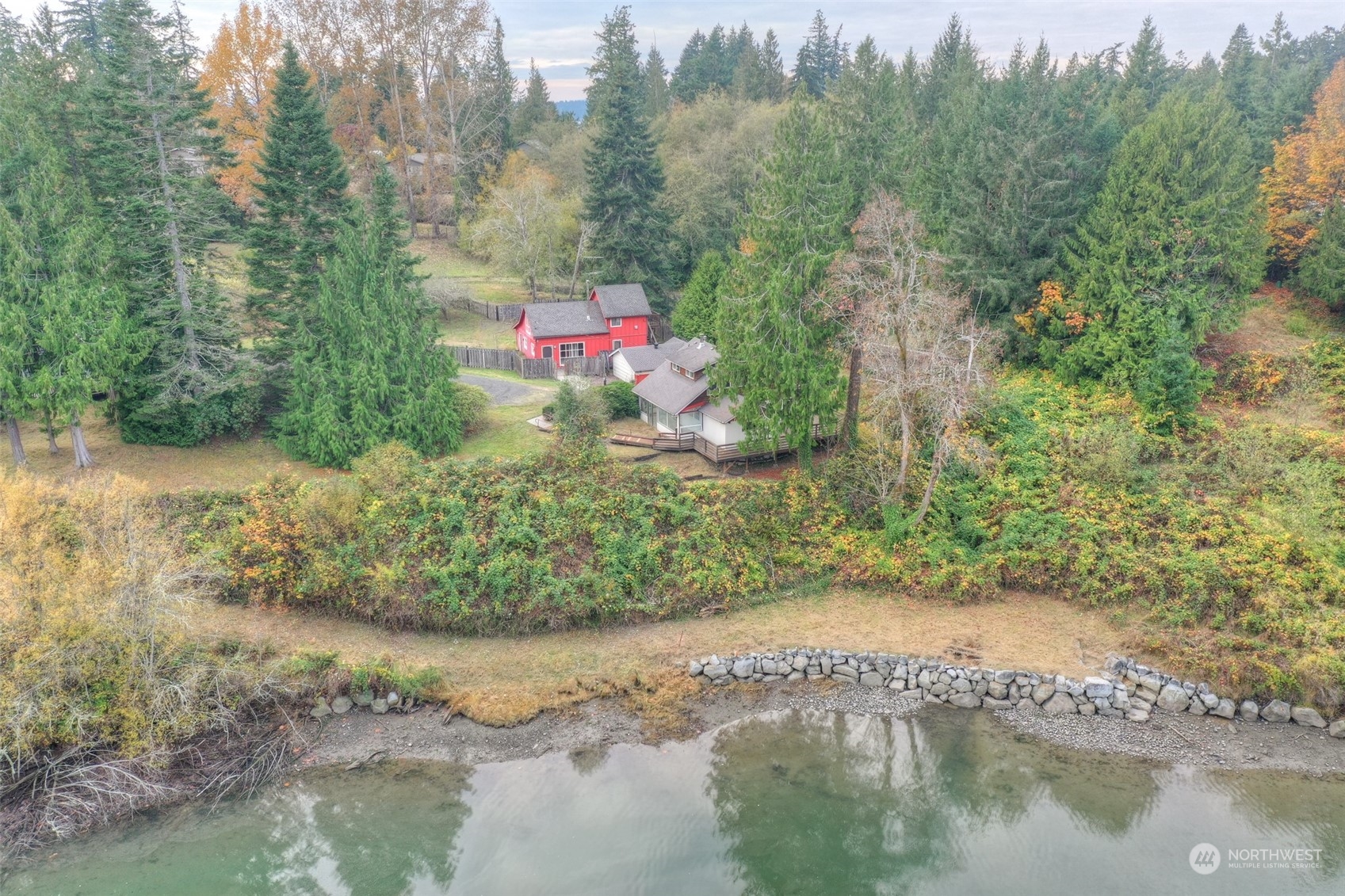 a aerial view of a house with a yard and lake view