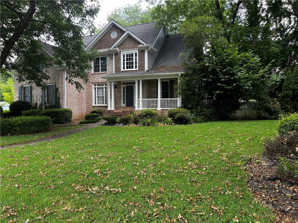 a front view of a house with garden and trees