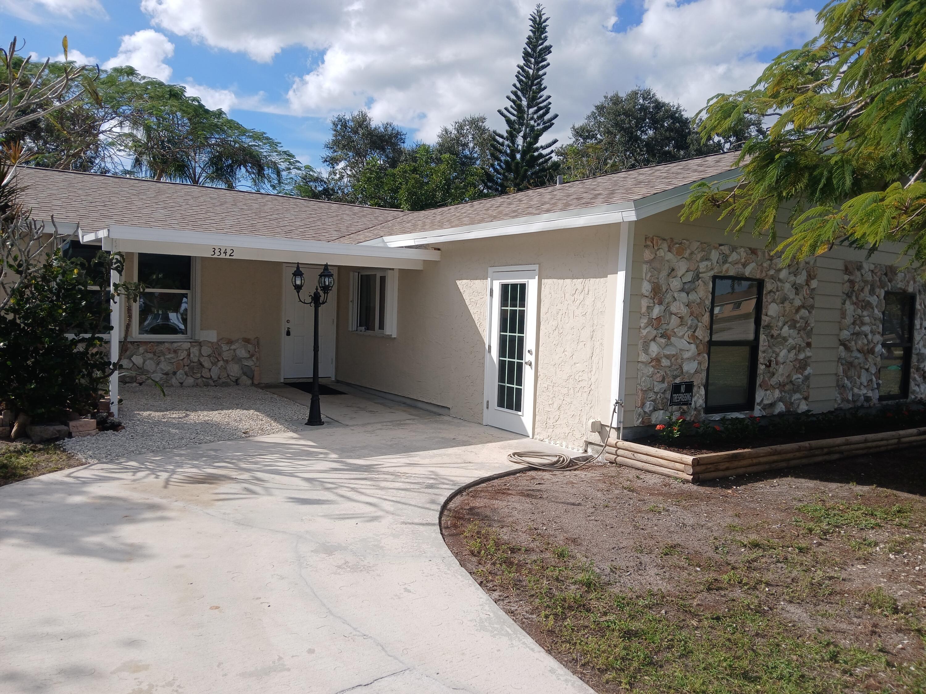 a view of a house with backyard and trees