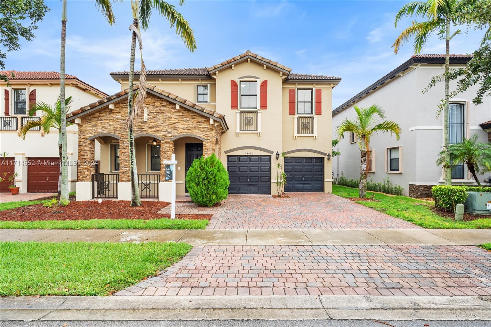 a front view of a house with a yard and potted plants