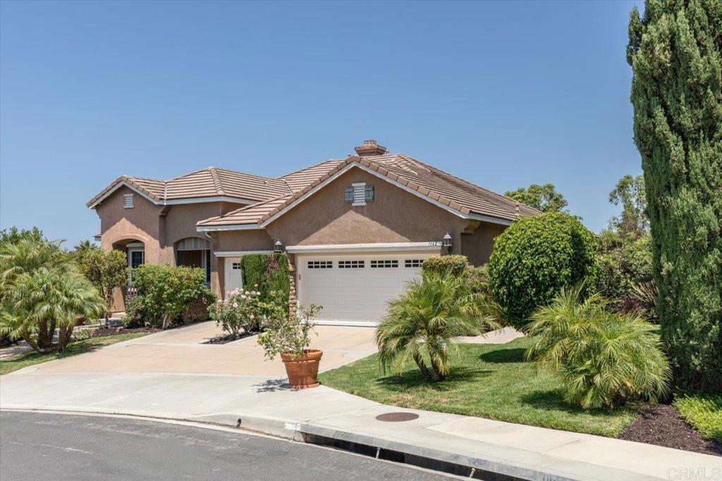 a front view of a house with a yard and potted plants