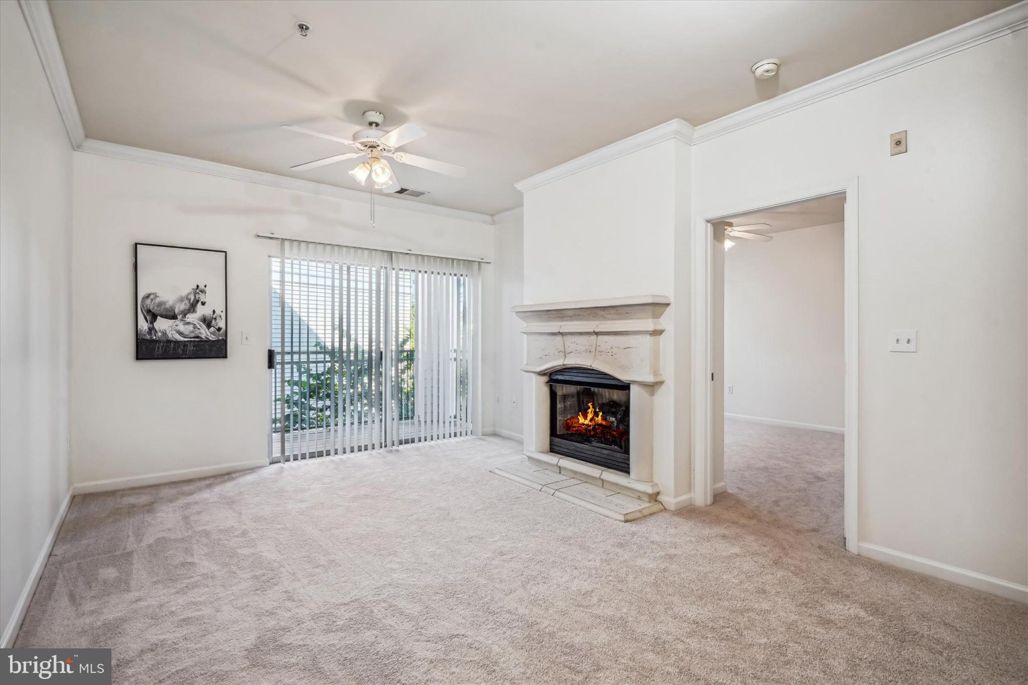 a view of an empty room with a fireplace and a window