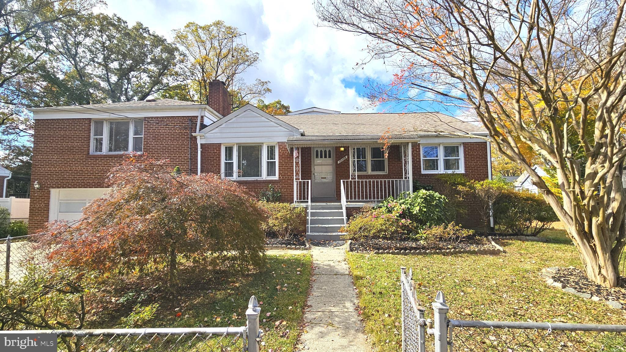 a front view of house with yard and trees around