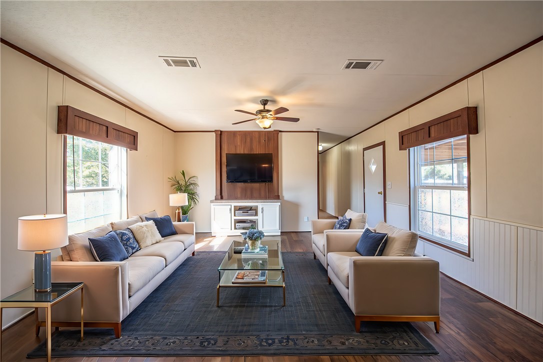 a living room with furniture flat screen tv and a large window