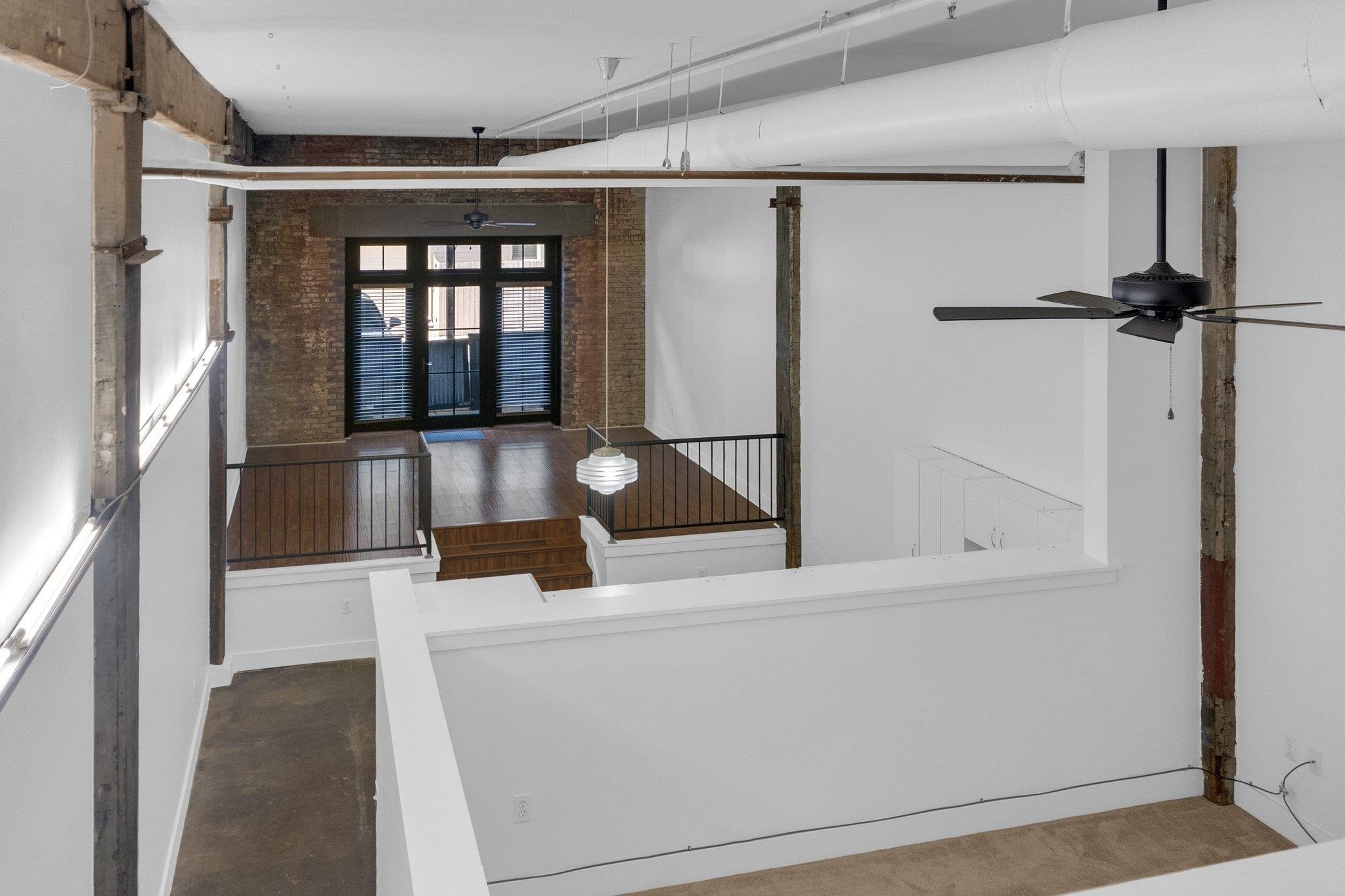 a hallway with white doors wooden floor and front door