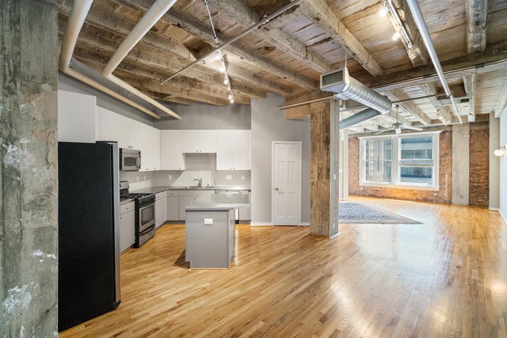 a open kitchen with a sink and refrigerator