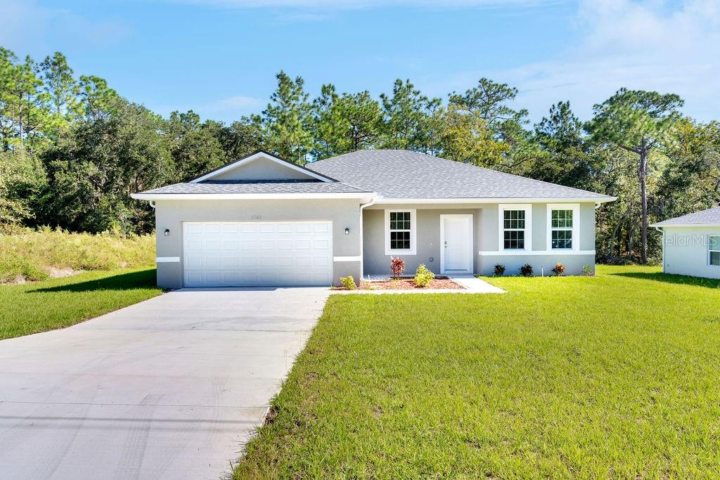 a front view of a house with yard patio and green space