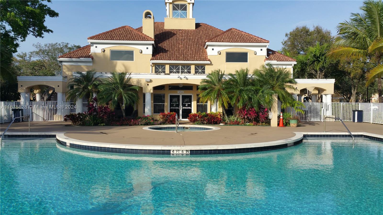 a view of a white house with a big yard and potted plants