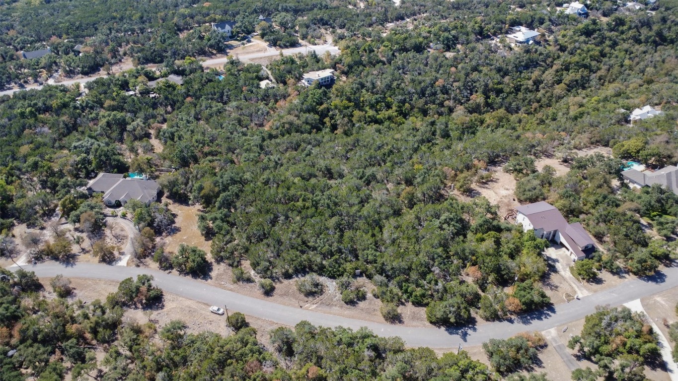 an aerial view of house with yard and trees in the background