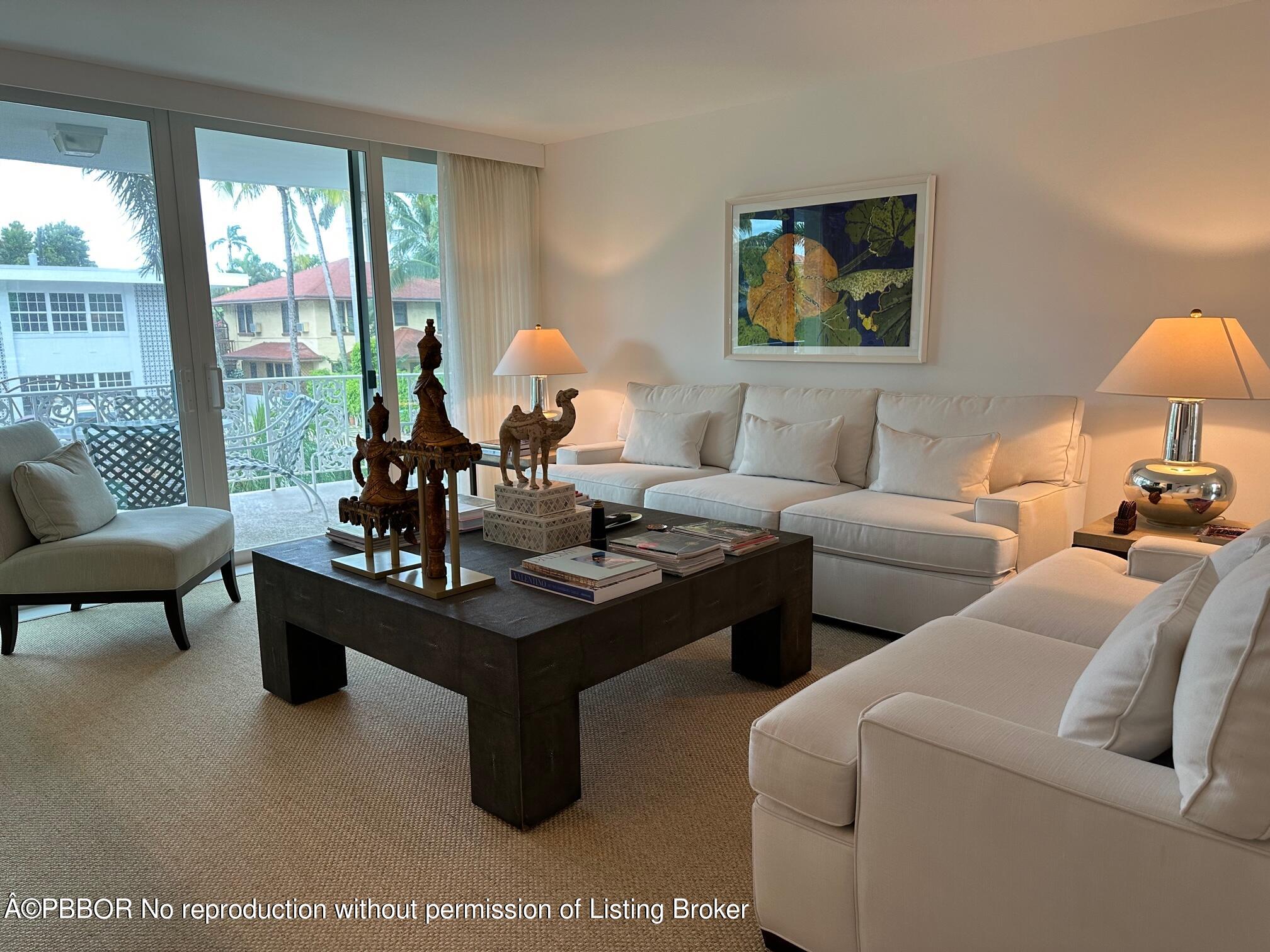 a living room with furniture a lamp a rug and a large window