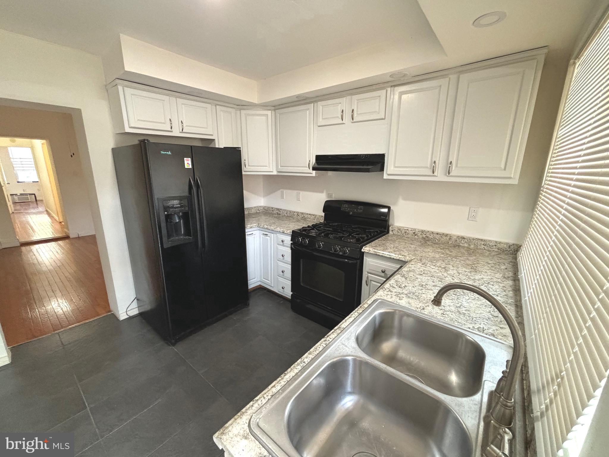 a kitchen with stainless steel appliances granite countertop a refrigerator and a sink